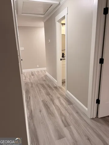 an empty room with wooden floor and entrance