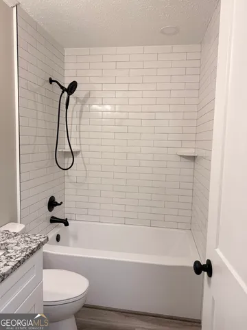 a bathroom with a toilet and a bath tub