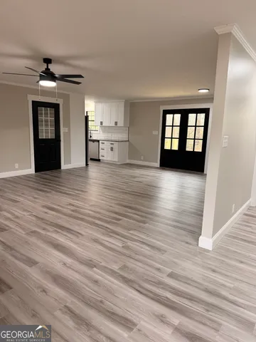 a view of empty room with wooden floor and window