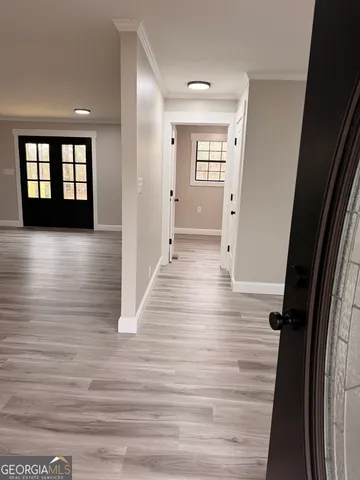 a view of a hallway with wooden floor and staircase