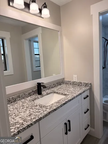 a bathroom with a granite countertop sink and a mirror