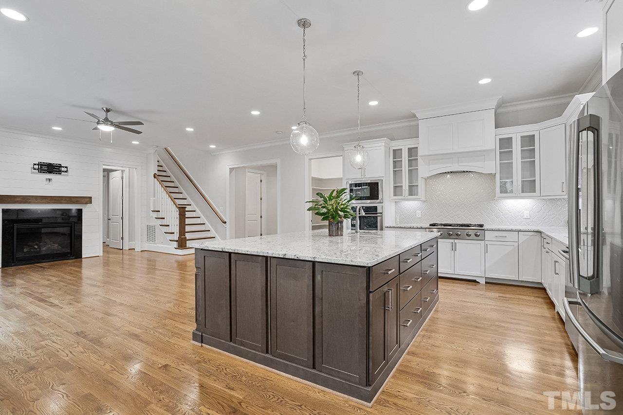 12309 Creedmoor Road Raleigh, NC 27613 - Photo 10 of 38 a large kitchen with stainless steel appliances kitchen island granite countertop a large counter top a sink a stove and a refrigerator