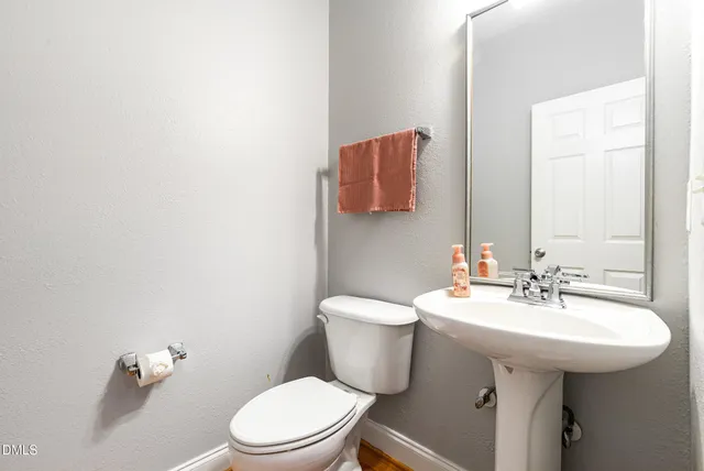 a bathroom with a sink a toilet and mirror