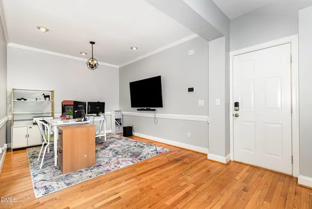 a living room with a flat screen tv and kitchen view