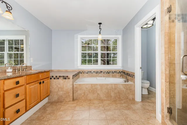 a bathroom with a tub sink and mirror
