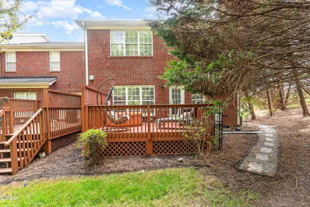 a view of a yard with large trees and wooden fence
