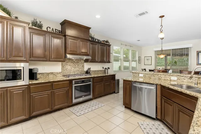 a kitchen with stainless steel appliances granite countertop a stove sink and cabinets