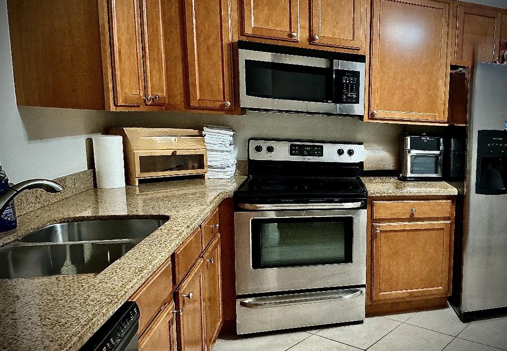 9774 Lancaster Place Boca Raton, FL 33434 - Photo 6 of 13 a kitchen with granite countertop a stove and a sink