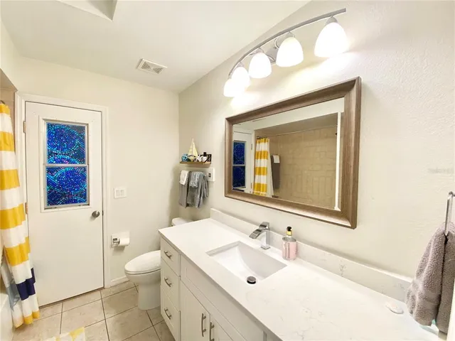 a bathroom with a toilet sink vanity and mirror