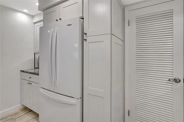 a view of a hallway with closet and wooden floor