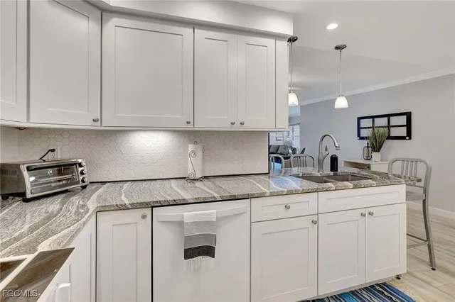 a kitchen with granite countertop white cabinets and white appliances