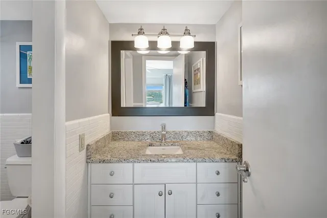 a bathroom with a granite countertop sink and a mirror