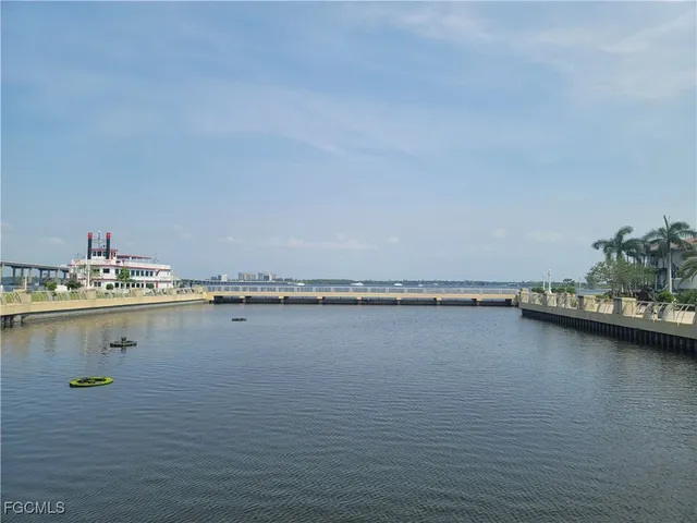a view of an ocean with boats and trees in the background