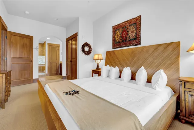 a bedroom with a large bed and a large mirror