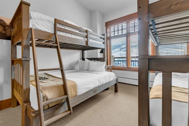 a bedroom with a bed and windows