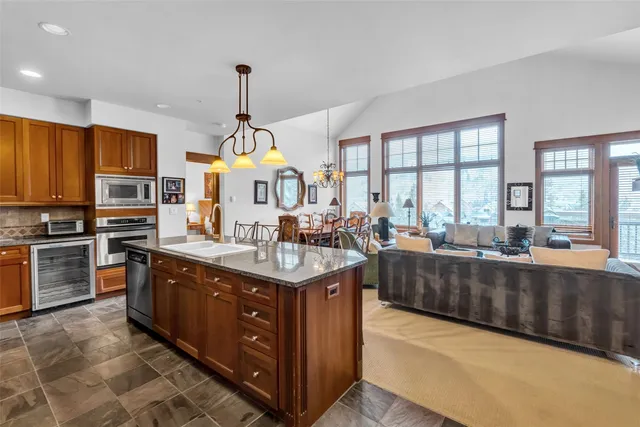 a kitchen with stainless steel appliances granite countertop a sink a stove and a refrigerator