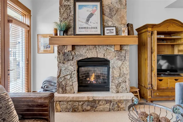 a living room with a fireplace and a flat screen tv