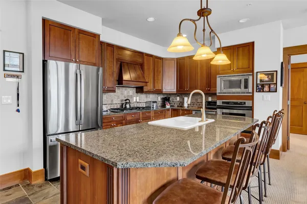 a kitchen with stainless steel appliances granite countertop a sink refrigerator and microwave