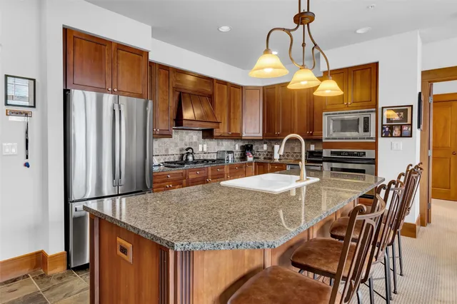 a kitchen with stainless steel appliances granite countertop a sink refrigerator and microwave