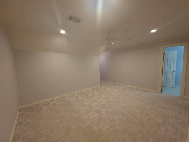 an empty room with a ceiling fan and a window