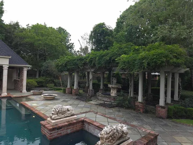 a swimming pool with outdoor seating and garden