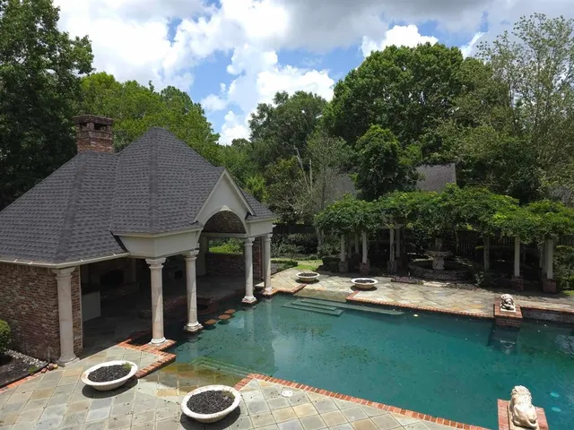 a view of a patio with table and chairs potted plants and large tree