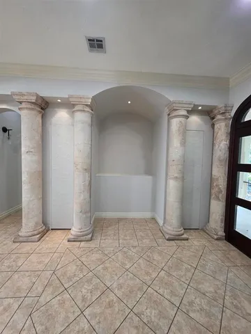 a view of an empty room with wooden floor and staircase