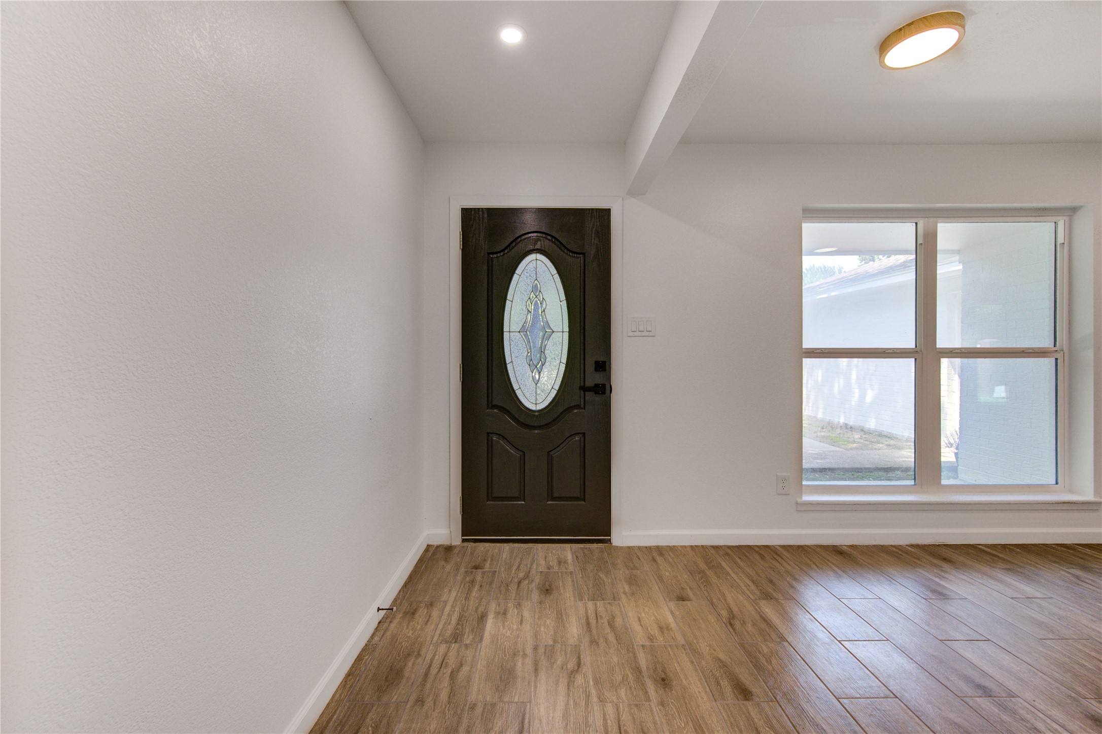 5411 Logston Lane Spring, TX 77389 - Photo 7 of 50 Inviting entryway with elegant wood-style flooring, a decorative front door, and ample natural light from a large window.