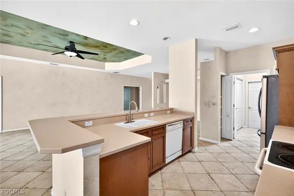 a kitchen that has a sink a stove a refrigerator and white cabinets with wooden floor