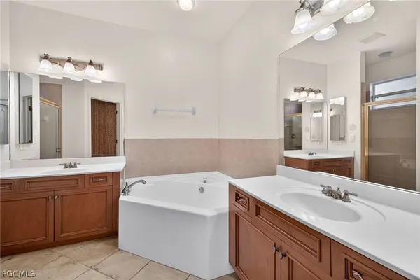 a bathroom with a sink vanity tub and a mirror
