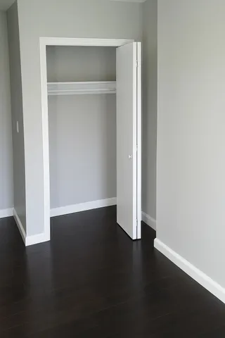 an empty room with wooden floor and closet