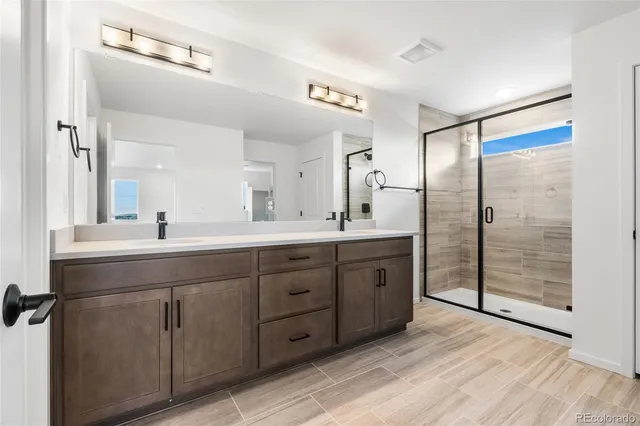 a spacious bathroom with a shower sink and mirror