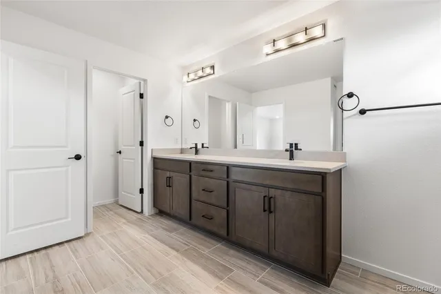 a spacious bathroom with a double vanity sink a mirror and a shower