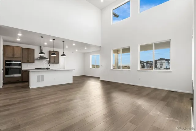 a view of kitchen with kitchen island wooden floor and stainless steel appliances