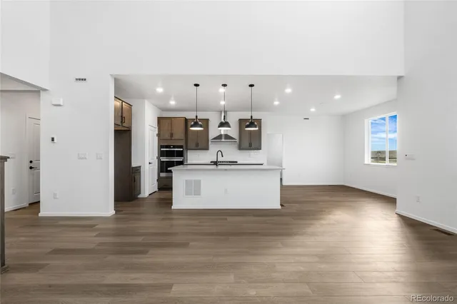 a large kitchen with stainless steel appliances kitchen island a large counter top and a fireplace