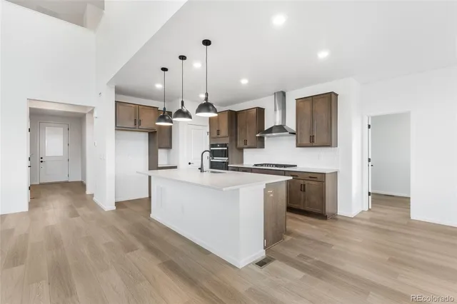 a kitchen with stainless steel appliances kitchen island wooden floors and white cabinets