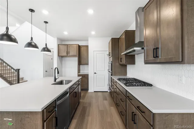 a kitchen with stainless steel appliances a sink a stove a refrigerator and cabinets