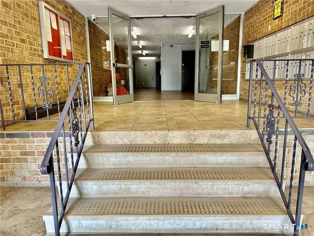 a view of staircase with white walls and a rug