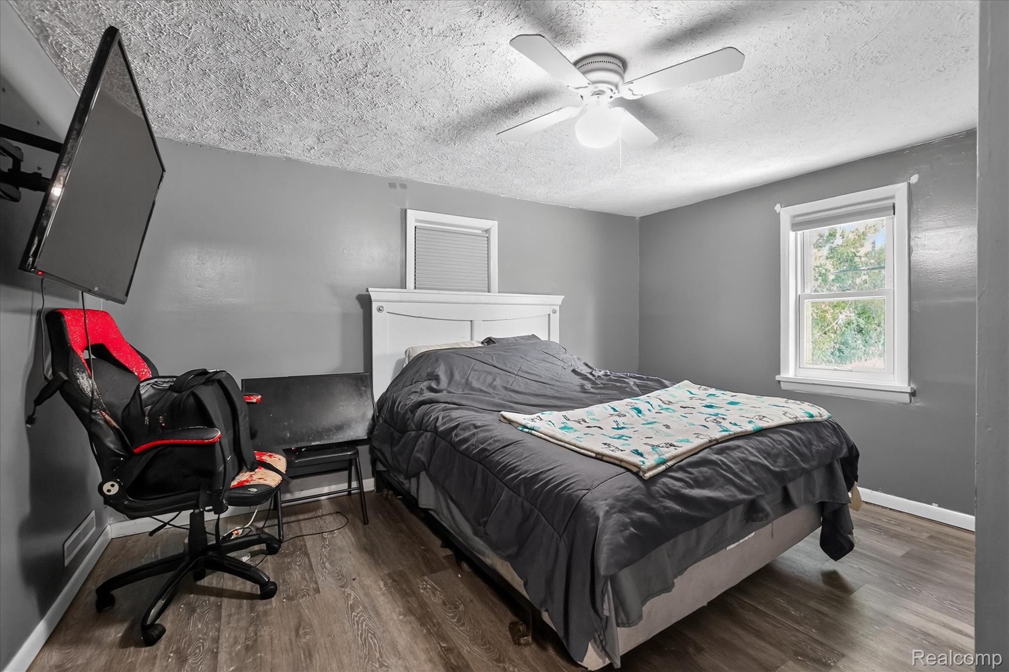 508 Deland Road Flushing, MI 48433 - Photo 19 of 38 Bedroom featuring wood-finish flooring, a white ceiling fan, and a single window with natural light