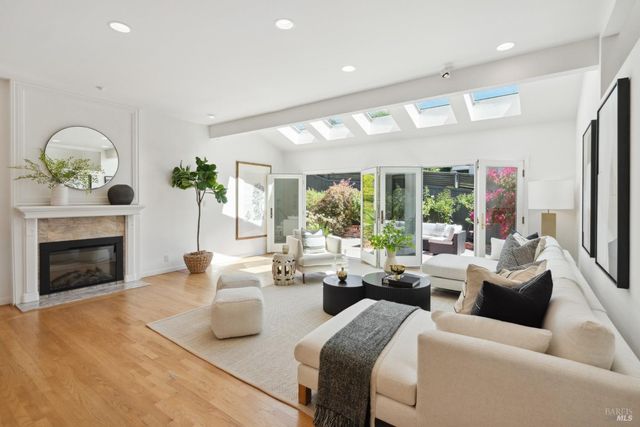 a living room with furniture a fireplace and a floor to ceiling window