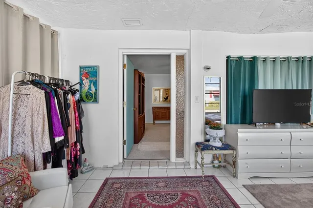 a view of a bedroom with a bed and a flat screen tv