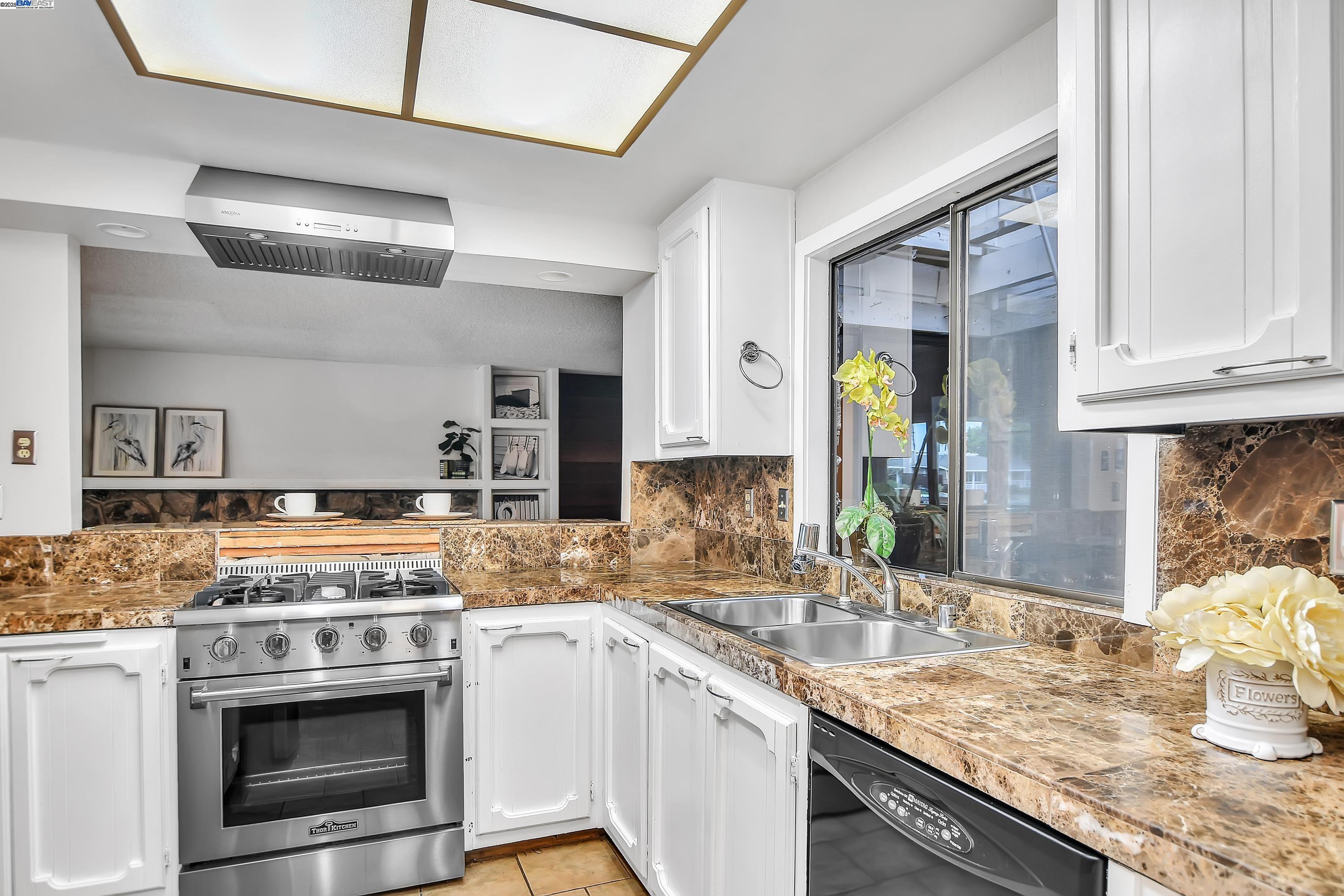 1402 Willow Lake Road Discovery Bay, CA 94505 - Photo 13 of 33 a kitchen with granite countertop stainless steel appliances a stove sink and cabinets