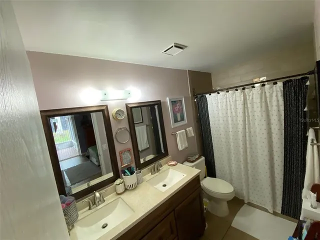 a bathroom with a sink a toilet a mirror and shower