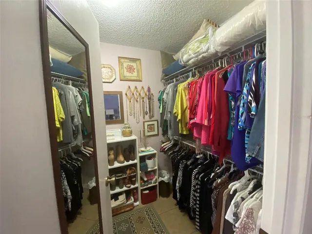 a view of walk in closet with clothes and shoes