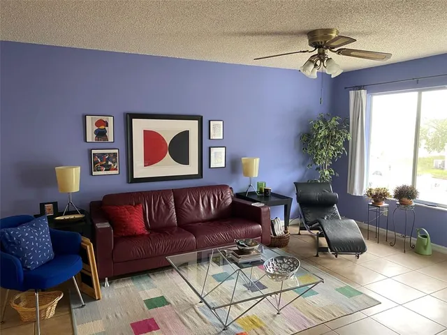 a living room with furniture a chandelier and a potted plant