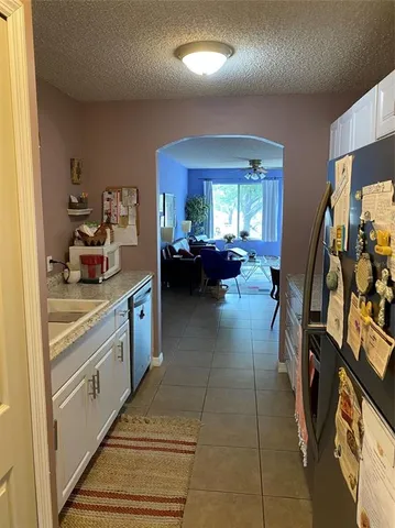 a kitchen with sink refrigerator and cabinets