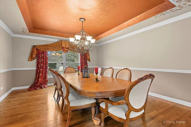 a bedroom with a bed a chandelier and a window
