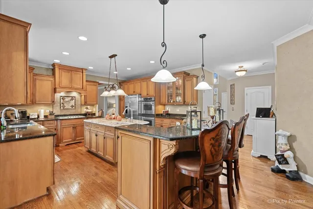 a kitchen with stainless steel appliances granite countertop a stove and a wooden floor
