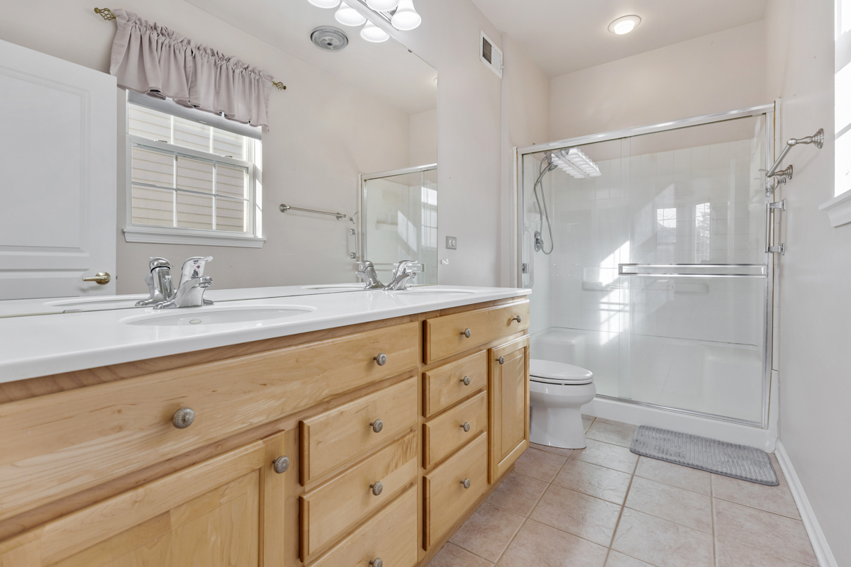 13567 Morgan Way Huntley, IL 60142 - Photo 14 of 26 a bathroom with a shower sink vanity mirror and toilet