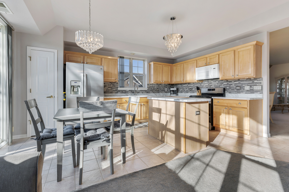 13567 Morgan Way Huntley, IL 60142 - Photo 2 of 26 a view of a dining room with furniture a chandelier and wooden floor